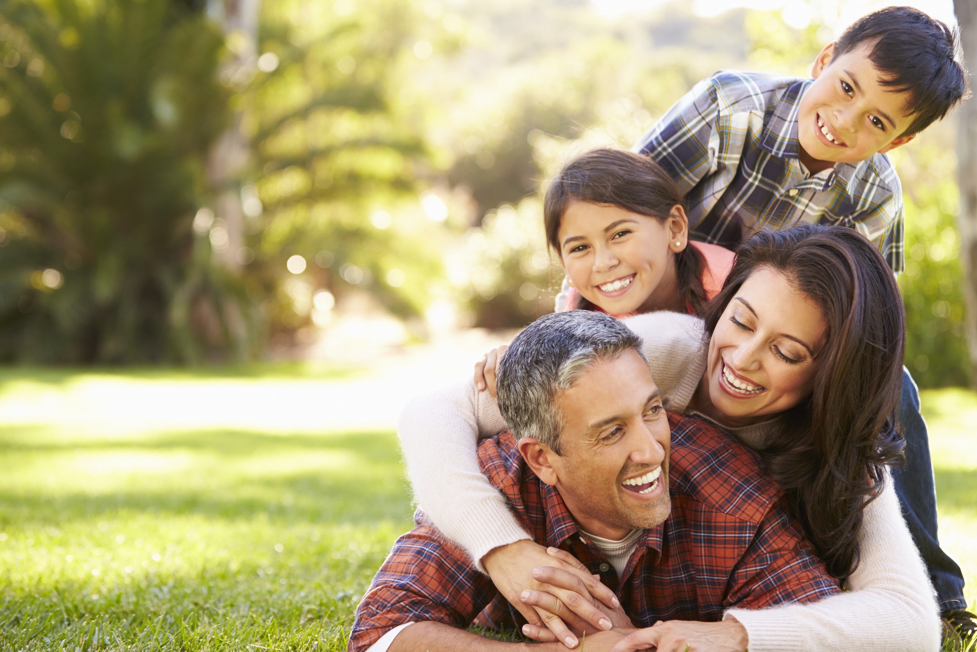 Family Lying On Grass In Countryside.